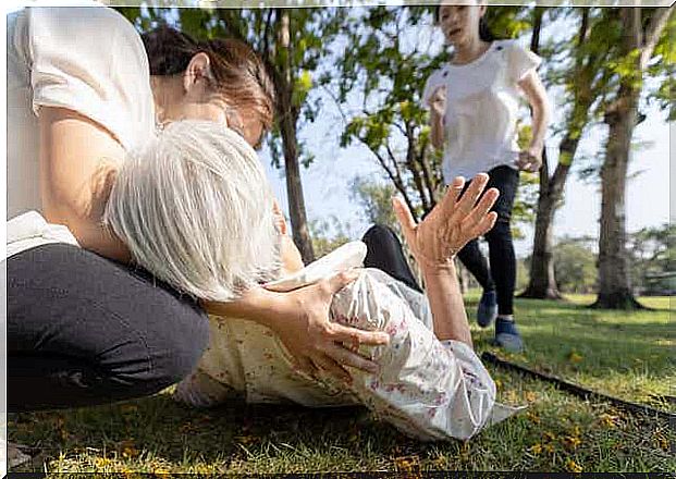 Elderly woman lying outside on the ground