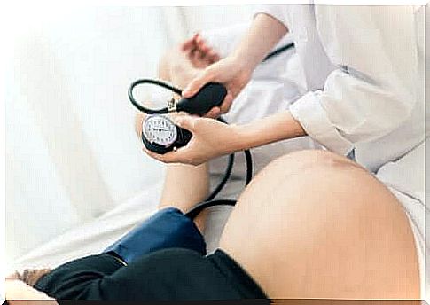 A doctor takes a pregnant woman's blood pressure