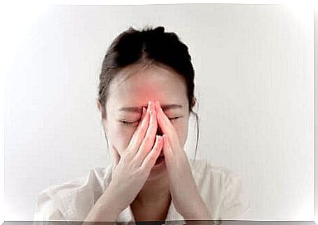 A woman holds her hands to her face