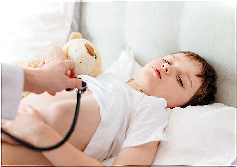 Boy with bear is checked by a doctor